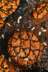 Fresh oatmeal cookies with sunflower seeds and chocolate glaze on a dark background.