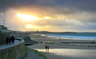 Promenade au coucher de soleil sur la plage du sillon de Saint Malo Intra Muros, Bretagne - obrazy, fototapety, plakaty