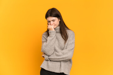 Fototapeta premium Young Ukrainian girl isolated on yellow background having doubts