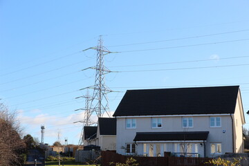 Electric pylon and g5 mast behind a house