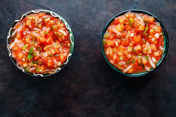 Bowl of mexican salsa sauce on a dark background. Traditional Latin American salsa sauce. Top view. Copy space