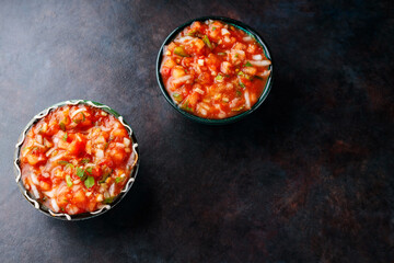 Bowl of mexican salsa sauce on a dark background. Traditional Latin American salsa sauce. Top view. Copy space