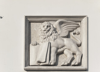 Simplified relief of venetian Saint Mark's winged lion with a book on old house wall in Lviv, Ukraine