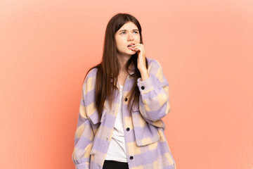 Young Ukrainian girl isolated on pink background is a little bit nervous