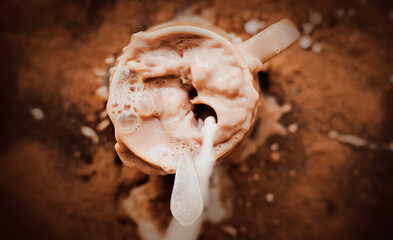 The human sloppily poured milk into a mug with warm cocoa. Mess in the kitchen. An invigorating...