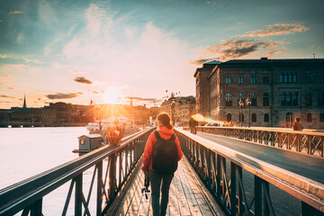 Stockholm, Sweden. Young Caucasian Woman Lady Tourist Traveler Walking On Famous Skeppsholmsbron -...