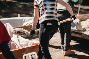 Woman shovelling gravel to build a wicking bed