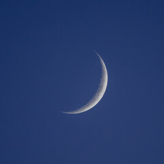 A waning crescent moon in a dark sky