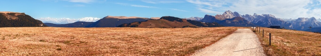 Hyper panorama of Seiser Alm plateau with a autumn scenic road. South Tyrol, Italy.