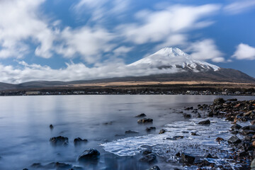 Mountain natural landscape beautiful background winter season. Mountain top snow and blue sky and blue water lake. Freezing water. Famous mountain Mt.Fuji In Japan