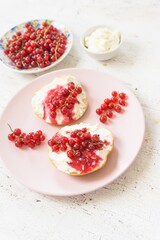 Healthy breakfast, toasts with curd cheese, berry jam and red currant berries, diet food, on a light vintage background, selective focus, close-up.