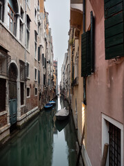 Fototapeta na wymiar Small Canal with Boats in Venice, Italy on a Cold Winter Day