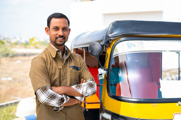 Happy confident driver with crossed arms standing by looking at camera - concept of confident, self...