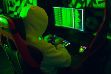 Hacker using computer malware software and hacking binary code green digital interface.