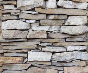 Masonry. Fragment of a wall made of rough natural stone. Gray stones