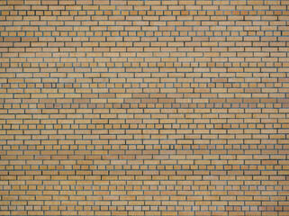 Brick texture. The wall of the house is made of yellow bricks. Frontal view
