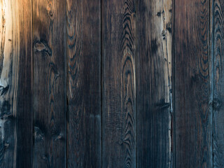 Plank fence made of dark old wood. Natural wood pattern. Surface fragment