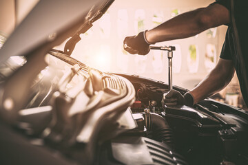 Close-up hand auto mechanic using the wrench to repairing car engine problem. Concepts of check and inspection car care maintenance and servicing.