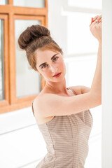 Portrait of a young beautiful woman in a short beige dress