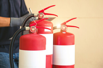 Naklejka premium Close up fire extinguisher and firefighter checking in the back for protection and prevent and safety rescue and use of equipment on fire training concept.