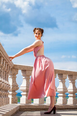 Full length portrait of young beautiful woman in pink dress