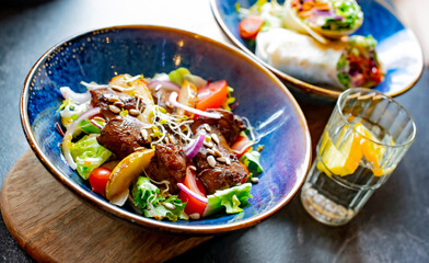 Vegetable salad with cooked pork and tortilla