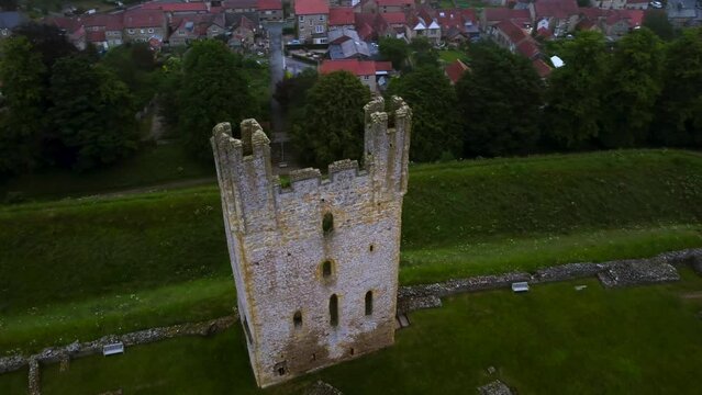 Drone helix of medieval Helmsley Castle, town and walled garden at dusk