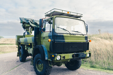 Large military transport truck in camouflaged paint.