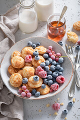 Dutch poffertjes with yoghurt and frozen berries.