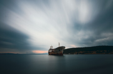 boat reflection calm sea long exposure piar tree clouds