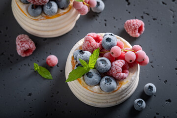 Homemade mini Pavlova dessert made of frozen berries and mascarpone. - obrazy, fototapety, plakaty