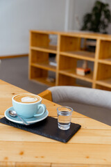 Fototapeta na wymiar Cup of hot cappuccino coffee on table