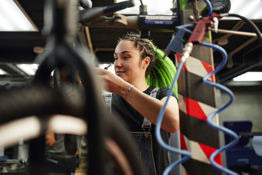 Female master smiling during repairing works in garage