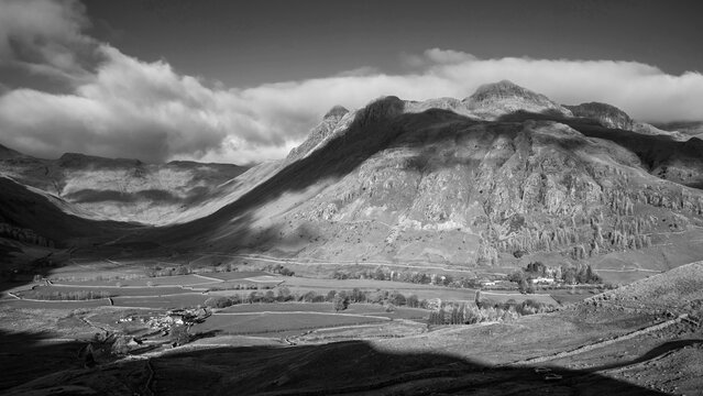 Black and white Colorful vibrant Autumn landscape image looking from Pike O'Blisco towards Langdale Pikes and Range with beautiful sungiht on mountains and valley