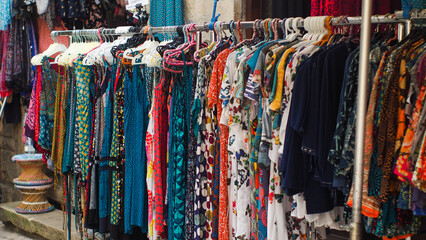 Exposition de vêtements dans un marché ouvert, dans la ville de Saint-Antonin-Noble-Val, en période estivale