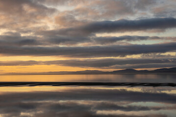 Obraz premium Beautiful sunset landscape image of Solway Firth viewed from Silloth during stunning Autumn sunset with dramatic sky and cloud formations