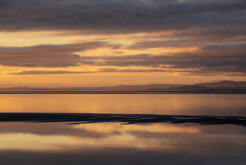 Fototapeta na wymiar Beautiful sunset landscape image of Solway Firth viewed from Silloth during stunning Autumn sunset with dramatic sky and cloud formations