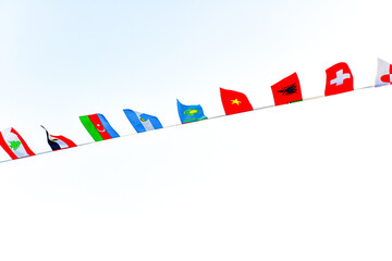 Flags of different countries are fixed and hanging on a rope.