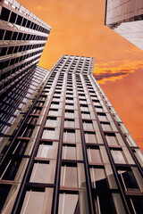 High-rise building photographed from bottom to top with a view of the red sky