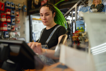 Focused woman working in store at cash register