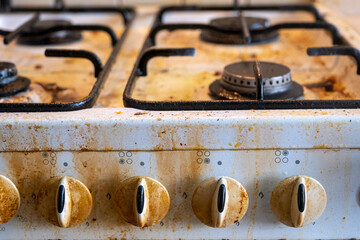 Dirty gas stove with food leftovers. Unsanitary conditions, mess in house. Top area surface and burner heads needs cleaning.