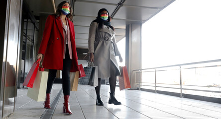 2 women leaving the mall with shopping bags