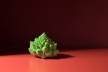 Romanesco variedad verde de coliflor y brócoli vegetales saludables aislado sobre fondo rojo