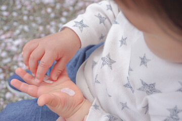 桜の花びらを拾う赤ちゃん