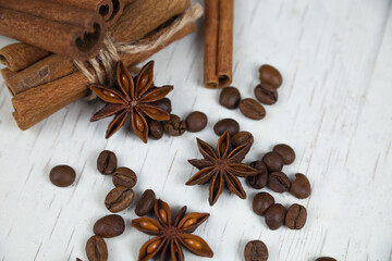 Cinnamon sticks, anise stars and coffee grains, on a gray wooden background close-up 