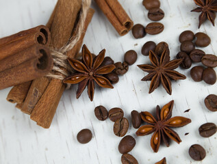 Cinnamon sticks, anise stars and coffee grains, on a gray wooden background close-up 