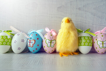 Easter eggs and yellow chicks on a grey background. The minimal concept. An Easter card with a copy of the place for the text