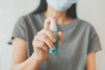senior woman's hand holding alcohol spray bottle  in soft focus, due to spread of corona virus,...