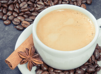 Coffee in cup and roasted dark coffee beans with anise and cinnamon