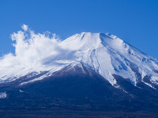 Fototapeta na wymiar 目が覚めるような青空に映える日本の美しい富士山の頂上
